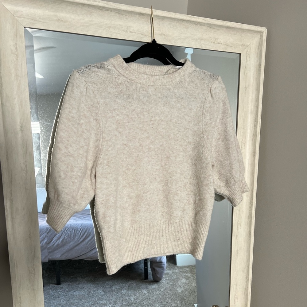 Cream sweater with puff shoulder feature.